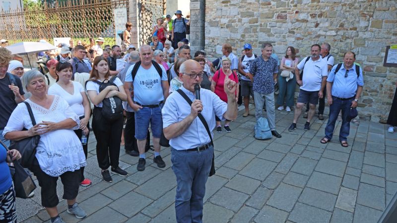 Program romanja se je začel z zborom romarjev pred oglejsko baziliko, kjer nas je nagovoril slovenski duhovnik v Štandrežu pri Gorici Karel Bolčina, vikar za Slovence v Gorici.