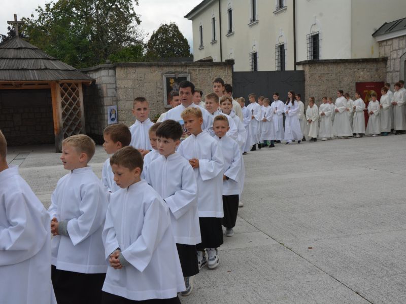 Dolga vrsta ministrantov in duhovnikov prihaja k maši na Brezjah. FOTO: Jože Pavlič