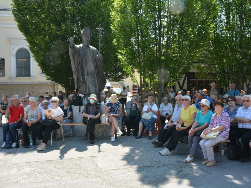 Nekateri romarji so začutili še posebno duhovno bližino s papežem sv. Janezom Pavlom II. ob njegovem kipu na Brezjah. FOTO: Jožef Pavlič